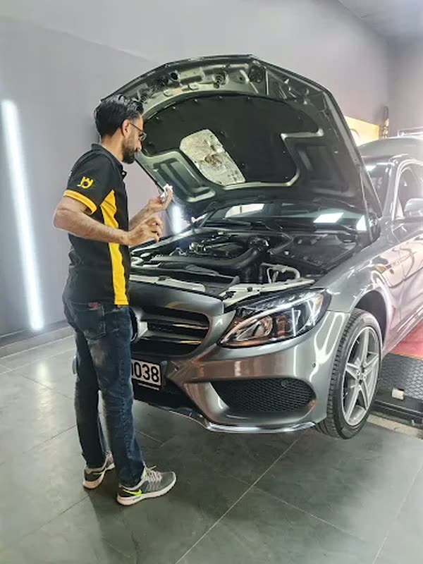 Kaputu açık araçta motor kontrolü yapan teknisyen